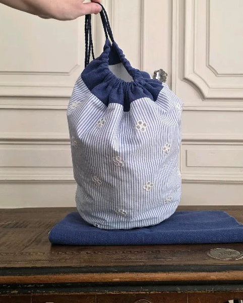 Sac baluchon broderie anglaise bleu et blanc posé, coton lin, forme souple à liens coulissants, confection artisanale