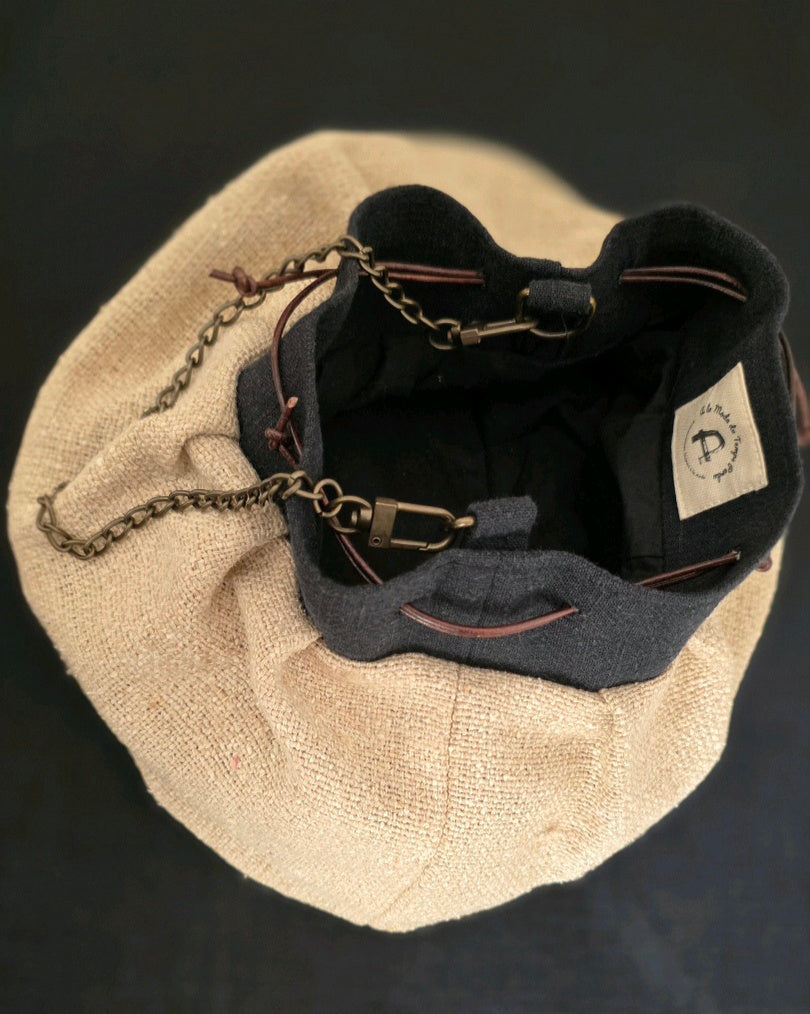 Vue de dessus du sac bourse en bourette de soie naturelle, intérieur doublé en percale de coton noir, fermeture par liens en cuir.
