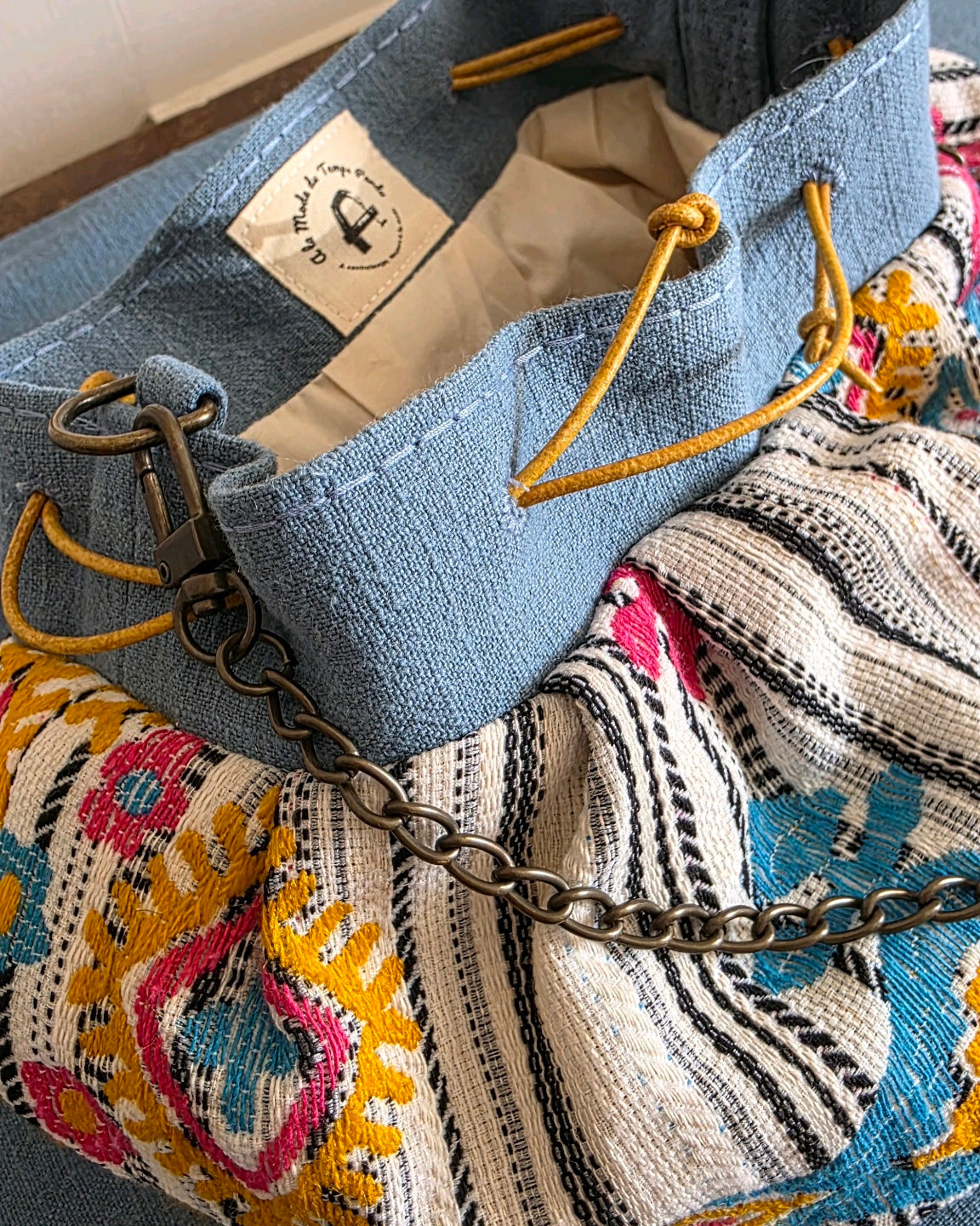 Intérieur du sac bourse en jacquard fantaisie Mahlia Kent, doublure en percale de coton, liens coulissants en cuir et chaînette amovible en laiton vieilli.