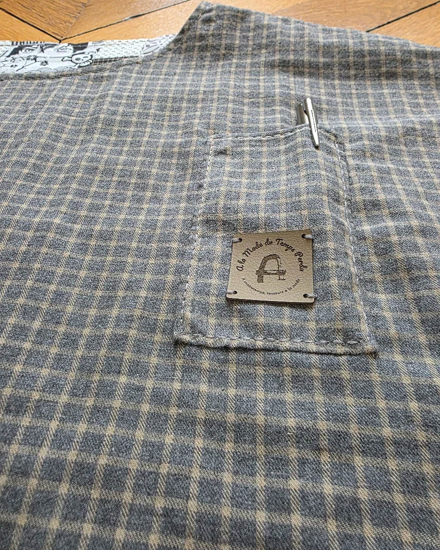 Détail de pochecà stylo et étiquette en cuir de cactus sur blouse réversible en coton patchwork