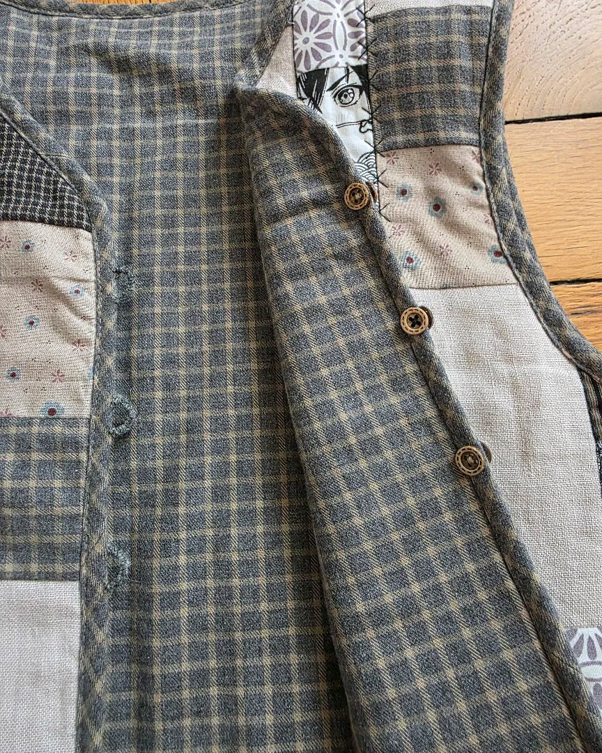 Gilet matelassé réversible sans manches en coton patchwork – vue à plat. Détail des brides et réversibilité. 