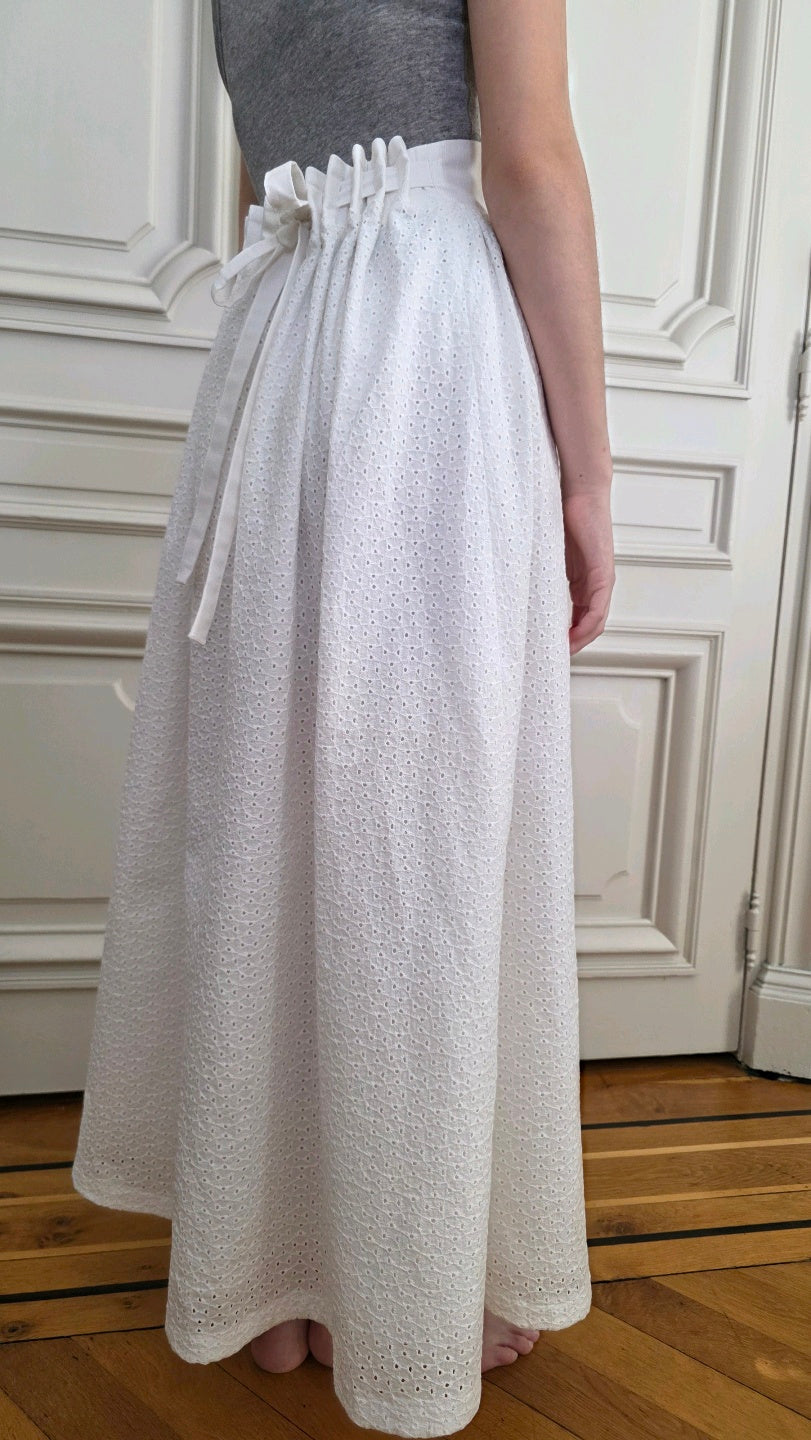 Jupe Alizé en broderie anglaise blanche, version sans volant, vue de trois quarts, avec taille ajustable par liens.