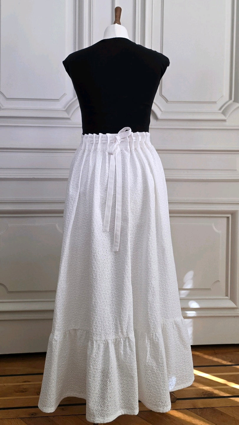 Jupe Alizé en broderie anglaise blanche, vue arrière sur mannequin, avec taille ajustable par liens à nouer et volant en bas de jupe.