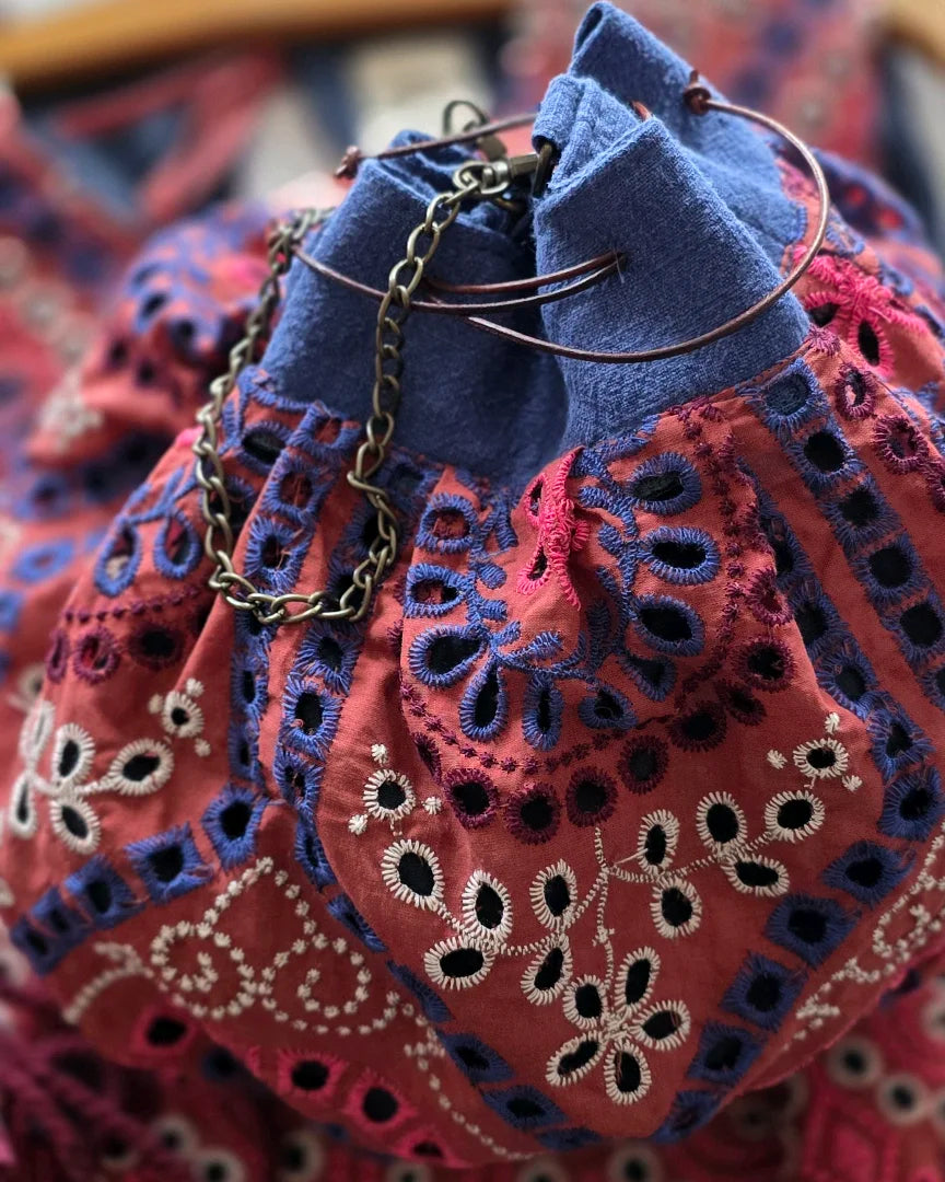 Détail fermeture sac bourse artisanal en broderie anglaise, liens cuir et chaîne métal, confection A la Mode du Temps Perdu