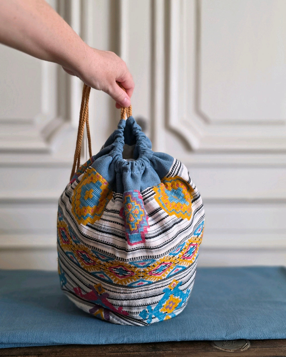 Sac baluchon en jacquard fantaisie Mahlia Kent porté à la main, forme souple et généreuse en lin.