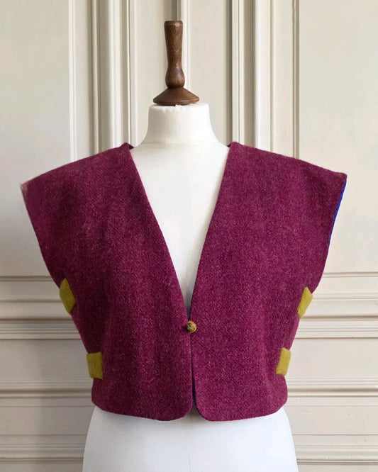  Boléro Harris Tweed framboise présenté de face sur mannequin, ouvert en V profond avec fermoir central.