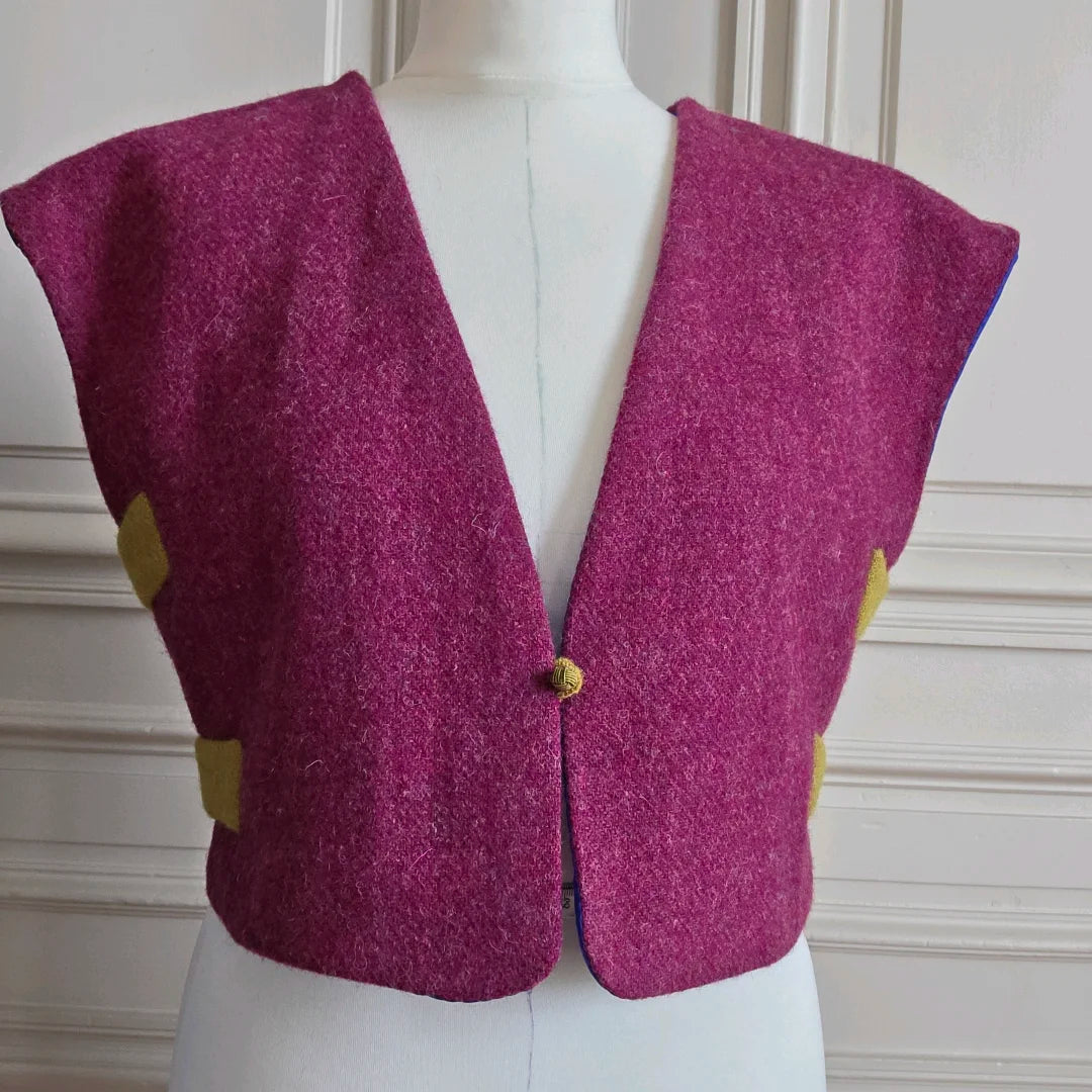 Vue rapprochée du boléro Harris Tweed framboise sur mannequin, mettant en valeur la texture de la laine et la coupe évasée des devants
