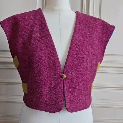 Vue rapprochée du boléro Harris Tweed framboise sur mannequin, mettant en valeur la texture de la laine et la coupe évasée des devants