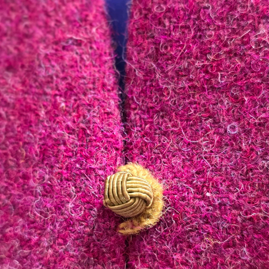 Vue de détail de la bride brodée à la laine et du petit bouton assorti du gilet boléro Oriane en tissu Harris Tweed et soie