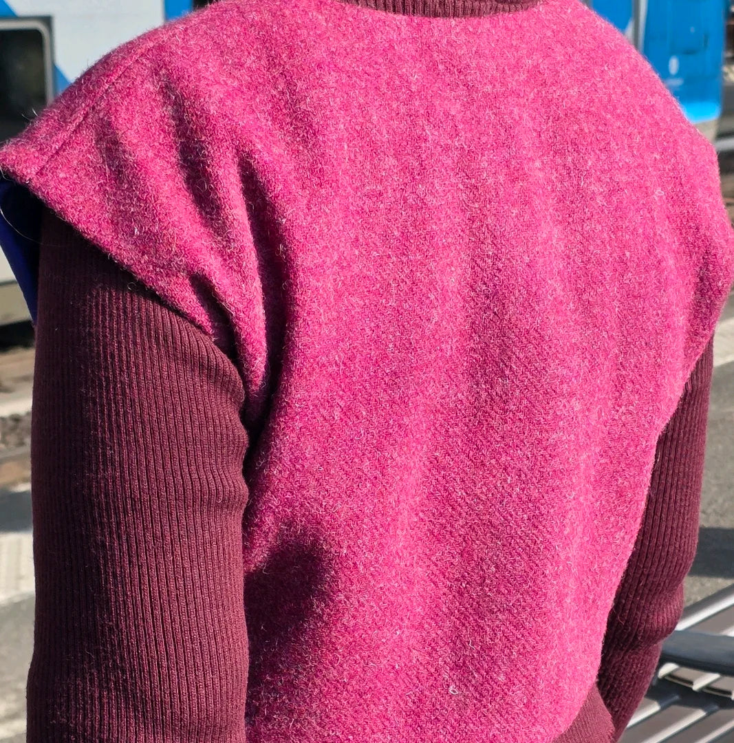 Vue de dos du boléro Harris Tweed fuchsia porté, montrant la ligne d’épaule légèrement descendue et la coupe courte au-dessus de la taille.
