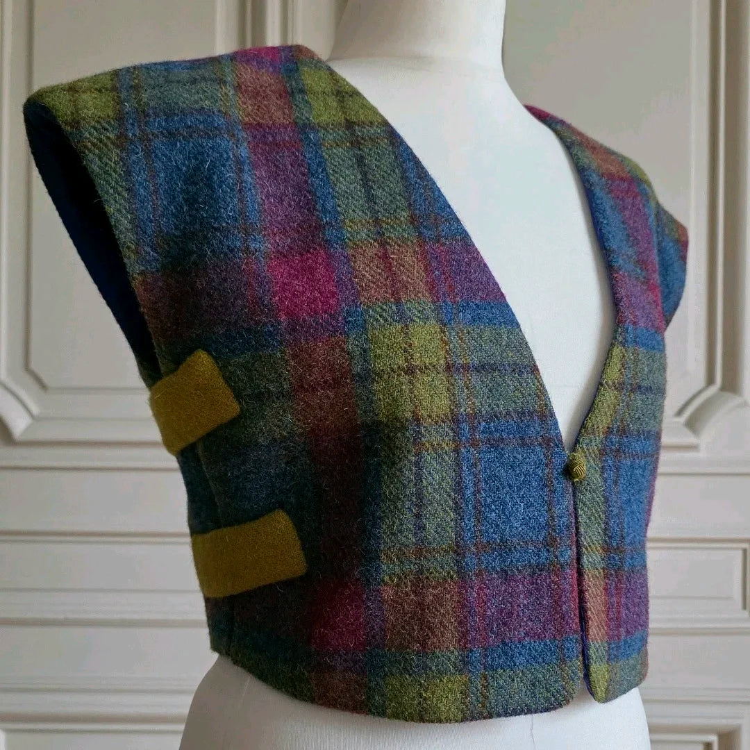 Gilet sans manche femme en Harris Tweed, modèle Odette, vue de 3/4, fermeture des côtés par brides  en tweed uni vert