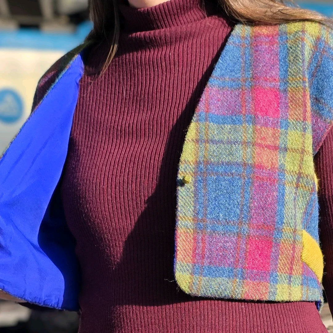 Boléro en Harris Tweed® porté par une femme de face. Le gilet est ouvert laissant apparaître la doublure en soie bleue. Lumières du soleil sur le tweed.