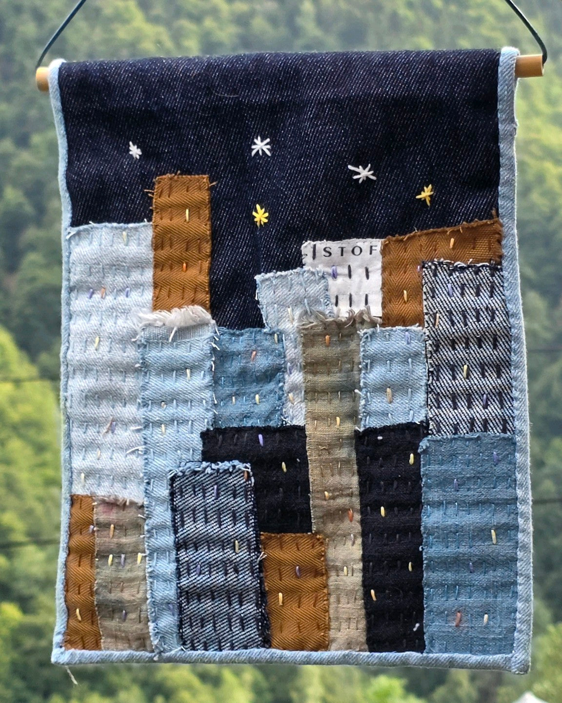 Détail de la tenture textile Échappée n°4 en denim, lin et coton avec broderies main