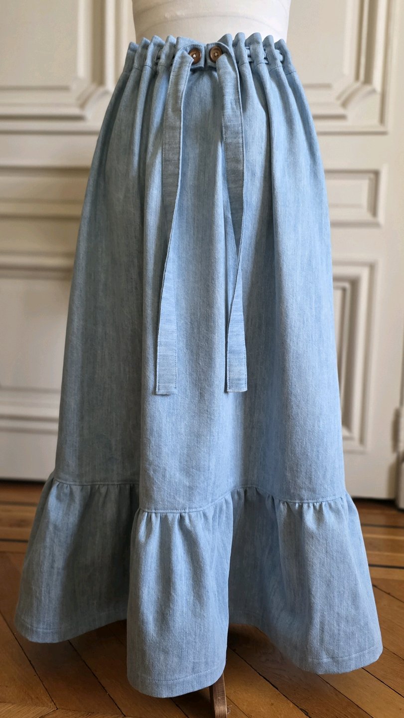 Jupe longue Bleu d'atelier – Variations Patines Opus III en denim délavé avec volant, boutons en bois et taille ajustable