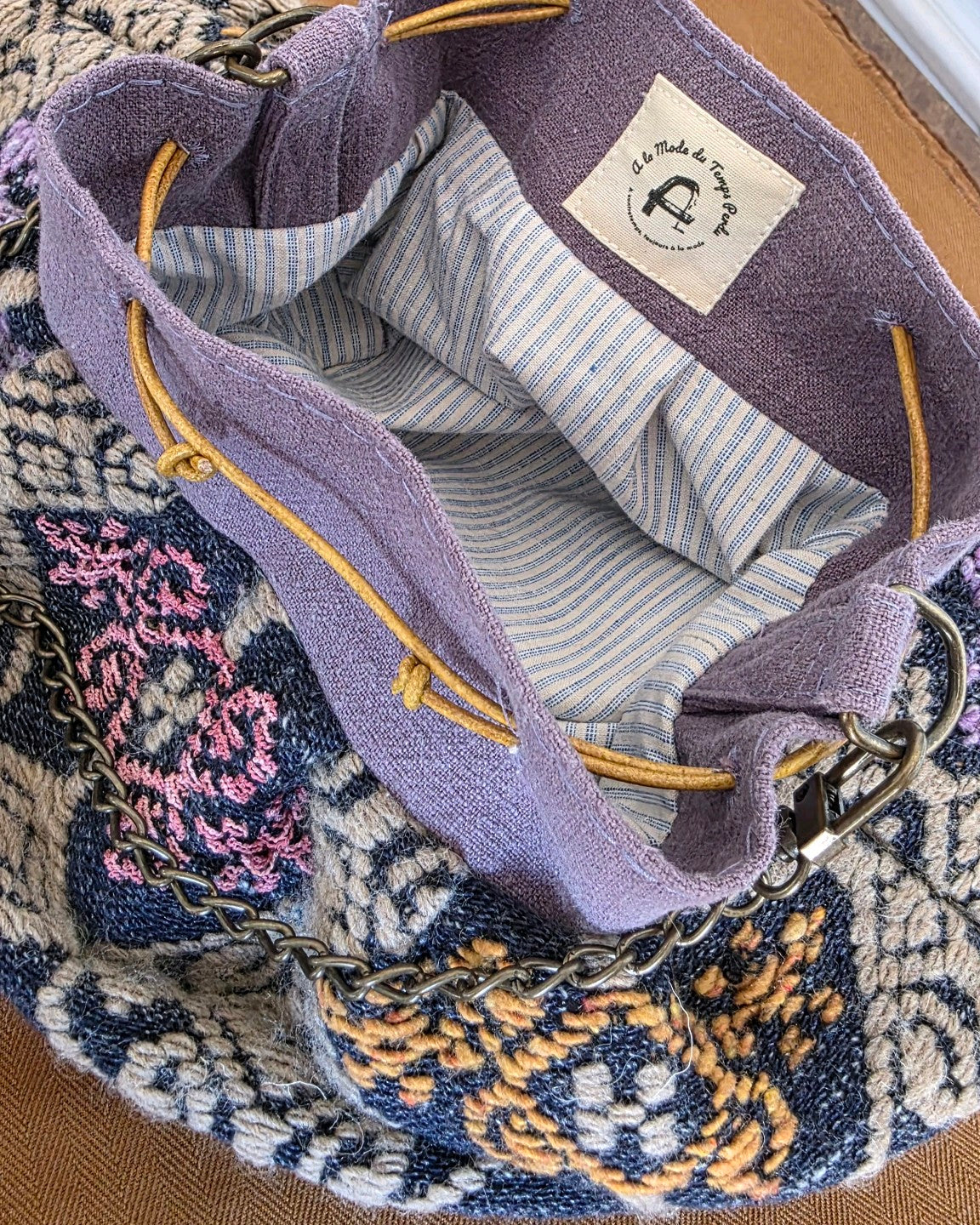 Intérieur du sac bourse en jacquard Mahlia Kent avec doublure en coton rayé, liens coulissants en cuir et finitions artisanales.