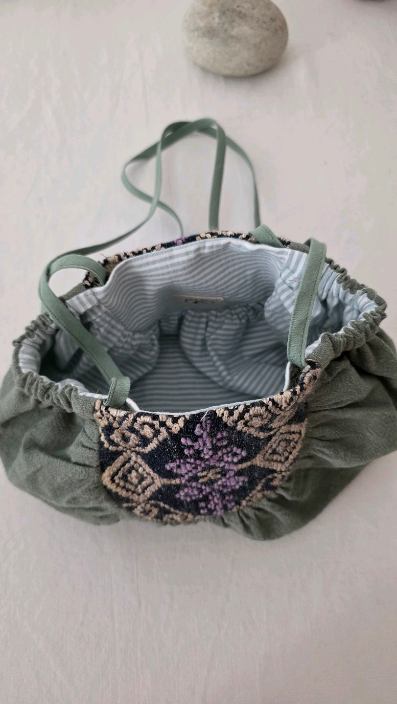 Intérieur du sac à main en lin coton vert avec doublure en coton rayé et finition artisanale.