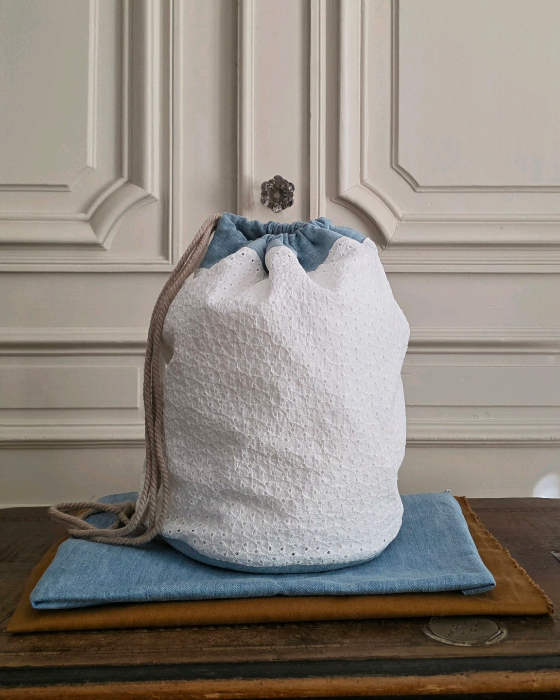 Sac baluchon fait main en broderie anglaise et denim, grand sac en coton blanc style bohème. Atelier A la Mode du Temps Perdu 