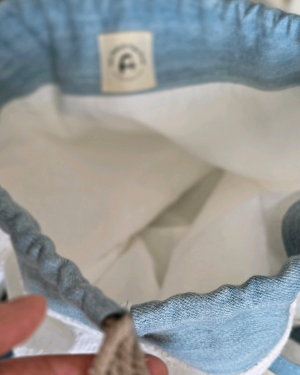 Intérieur du sac baluchon en coton avec doublure blanche, sac fait main en broderie anglaise et denim