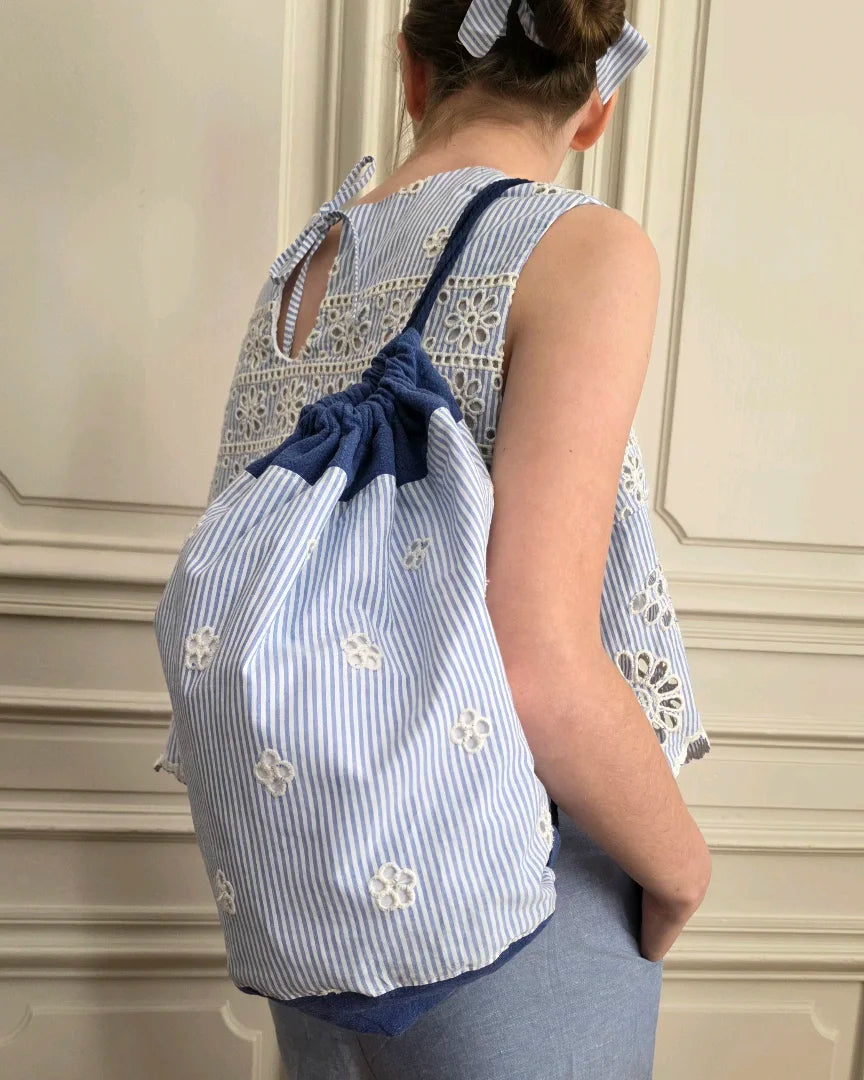 Sac baluchon broderie anglaise bleu porté dans le dos avec le top Alizé, coton lin, sac souple à liens coulissants, confection artisanale