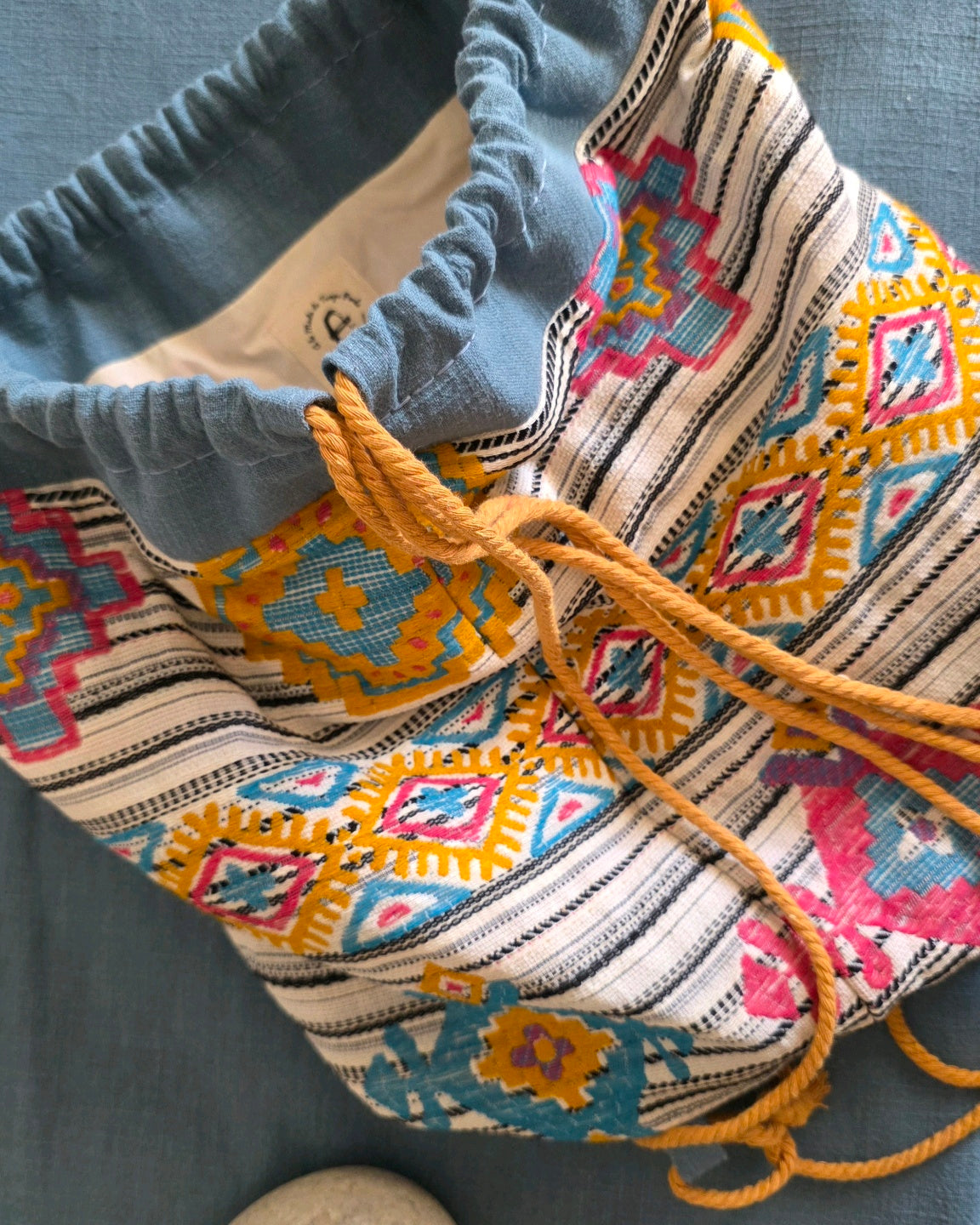 Détail du sac baluchon en jacquard fantaisie Mahlia Kent avec ouverture et liens coulissants.