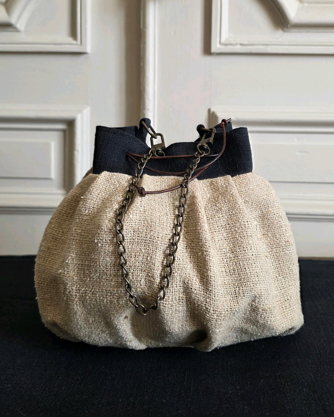 Dos du sac bourse artisanal en bourette de soie naturelle avec chaînette amovible en laiton vieilli et détails en lin noir.