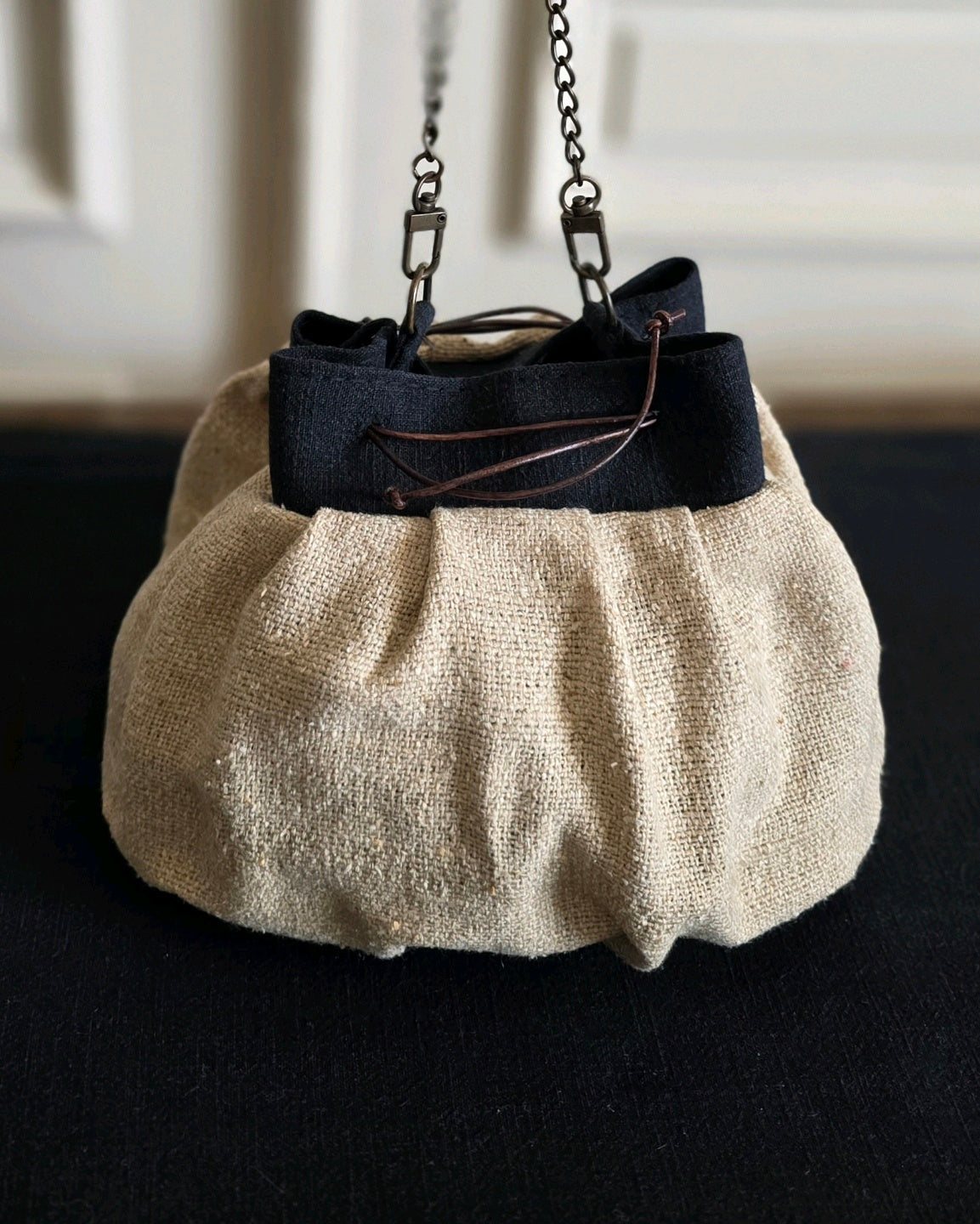 Sac bourse artisanal en bourette de soie naturelle avec détail en lin noir, liens coulissants en cuir et chaînette en laiton vieilli. Atelier A la Mode du Temps Perdu 