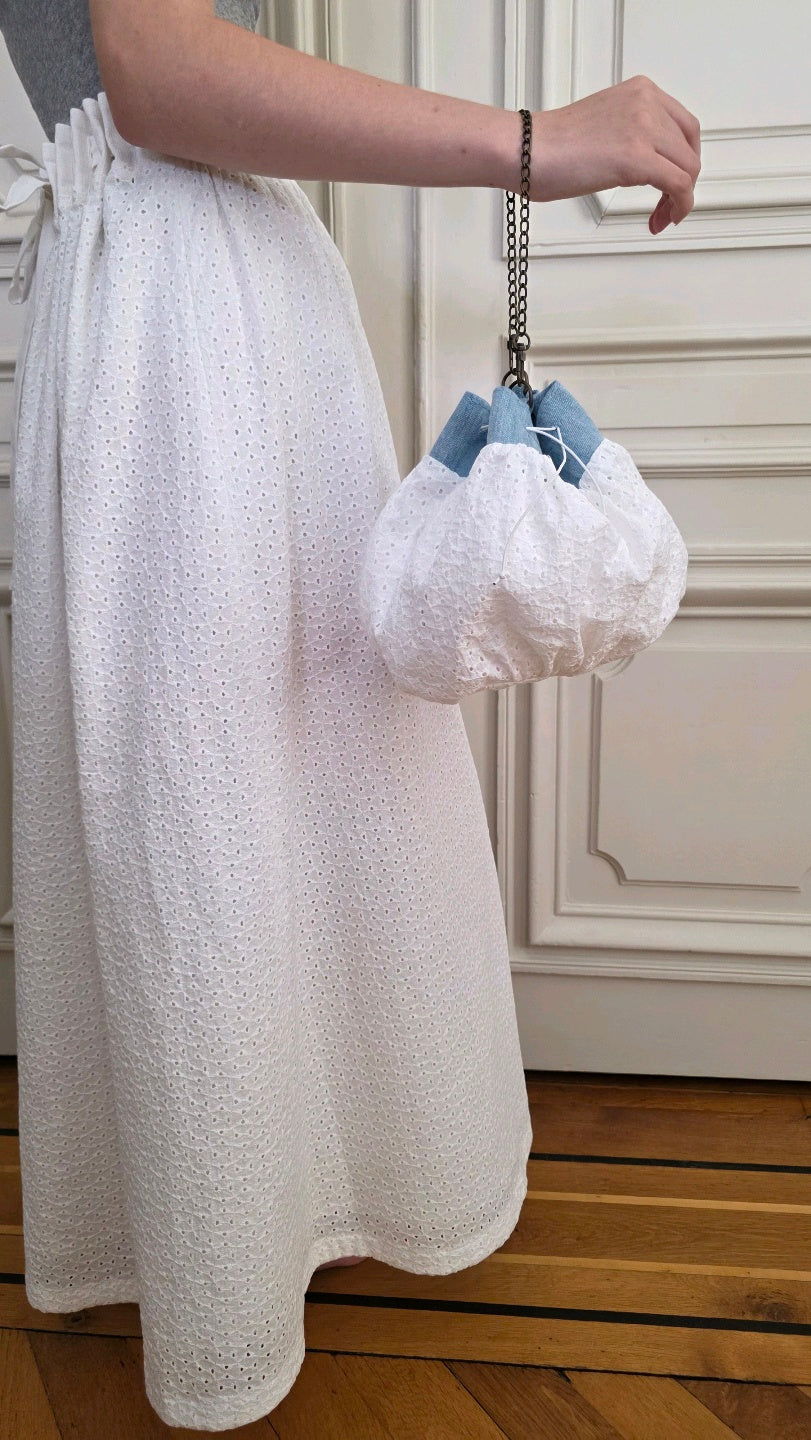 Sac bourse fait main en broderie anglaise et denim porté avec une jupe Alizé blanche
