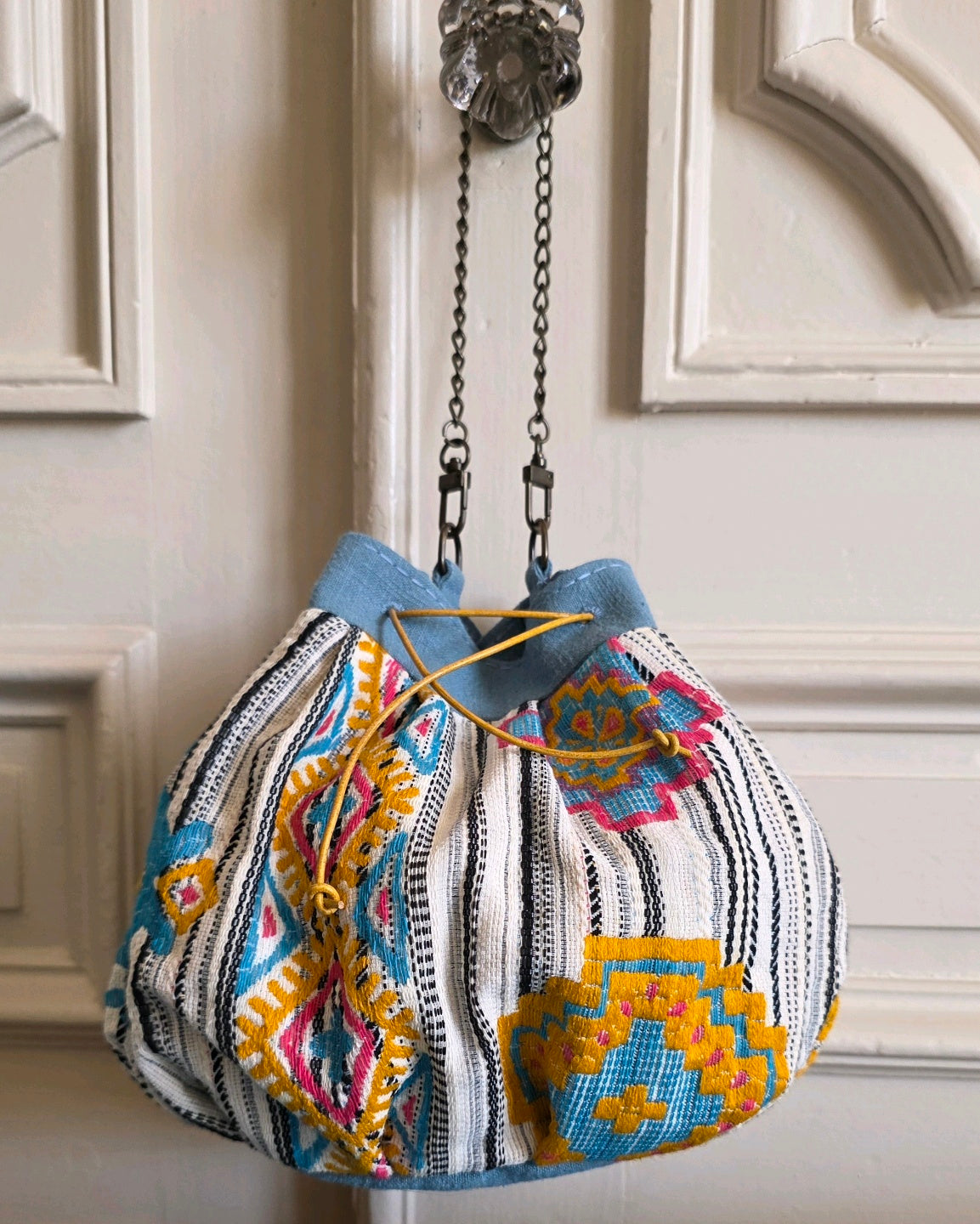 Sac bourse Mahlia Kent porté par sa chaînette amovible en laiton vieilli.