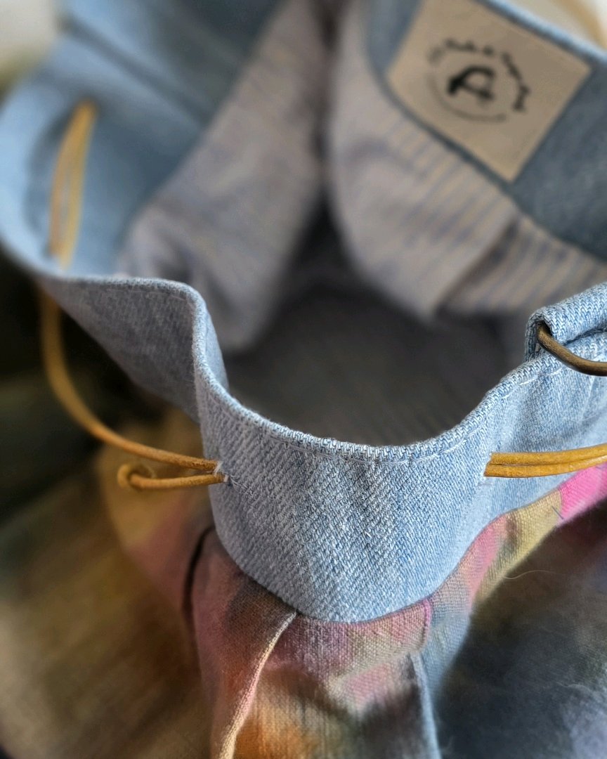 Détail du sac bourse en lin coton tie and dye avec finition en jean, doublure coton rayée et fermeture coulissante