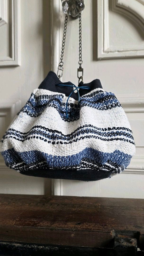 Sac bourse bleu marine et écru suspendu par sa chaînette amovible en laiton vieilli