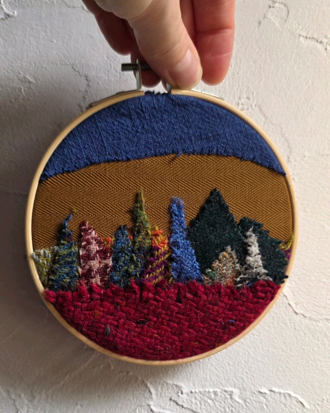 Échappée n°6 accrochée au mur, tableau textile artisanal en tweed de 12 cm