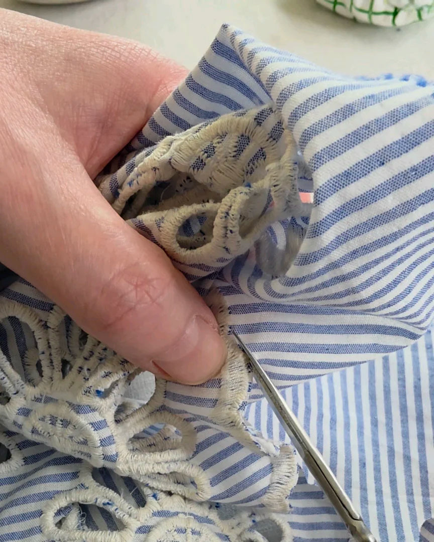 Détail couture à la main broderie anglaise Alizé, finition ciseaux, travail artisanal en atelier, pièce faite main