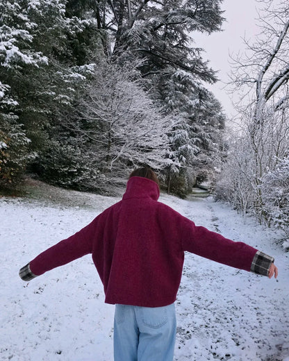 Vue dos veste Harris Tweed framboise portée dans les bois, sous la neige, ampleur du dos bras ouverts.