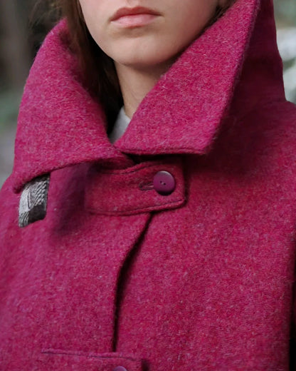 Détail col oversize ouvert veste tweed framboise portée sous la neige.