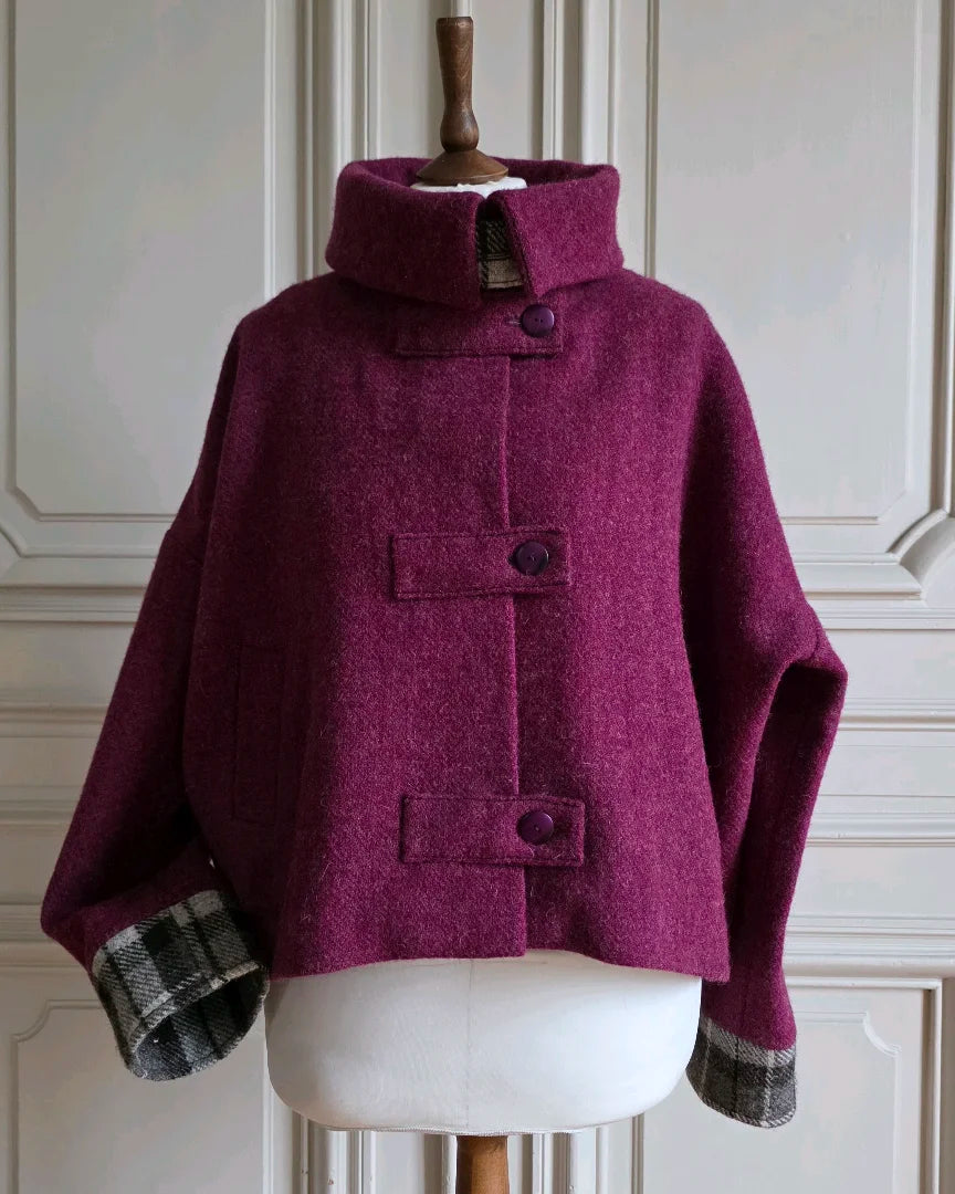 Veste Harris Tweed femme Albertine col montant façon col roulé.
Mannequin devant portes blanches.