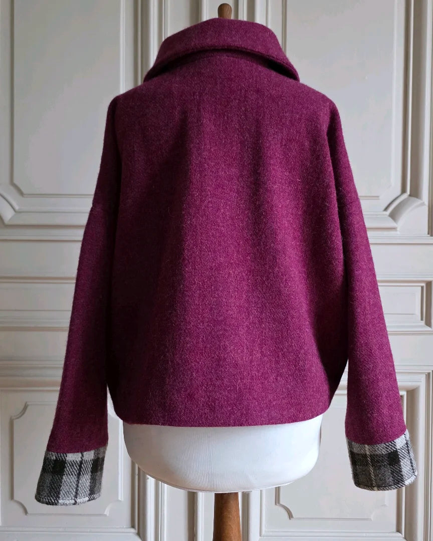 Vue dos veste Harris Tweed et soie femme Albertine col ouvert.
Manches amples avec bracelets tartan noir gris blanc.
Mannequin devant portes haussmanniennes.