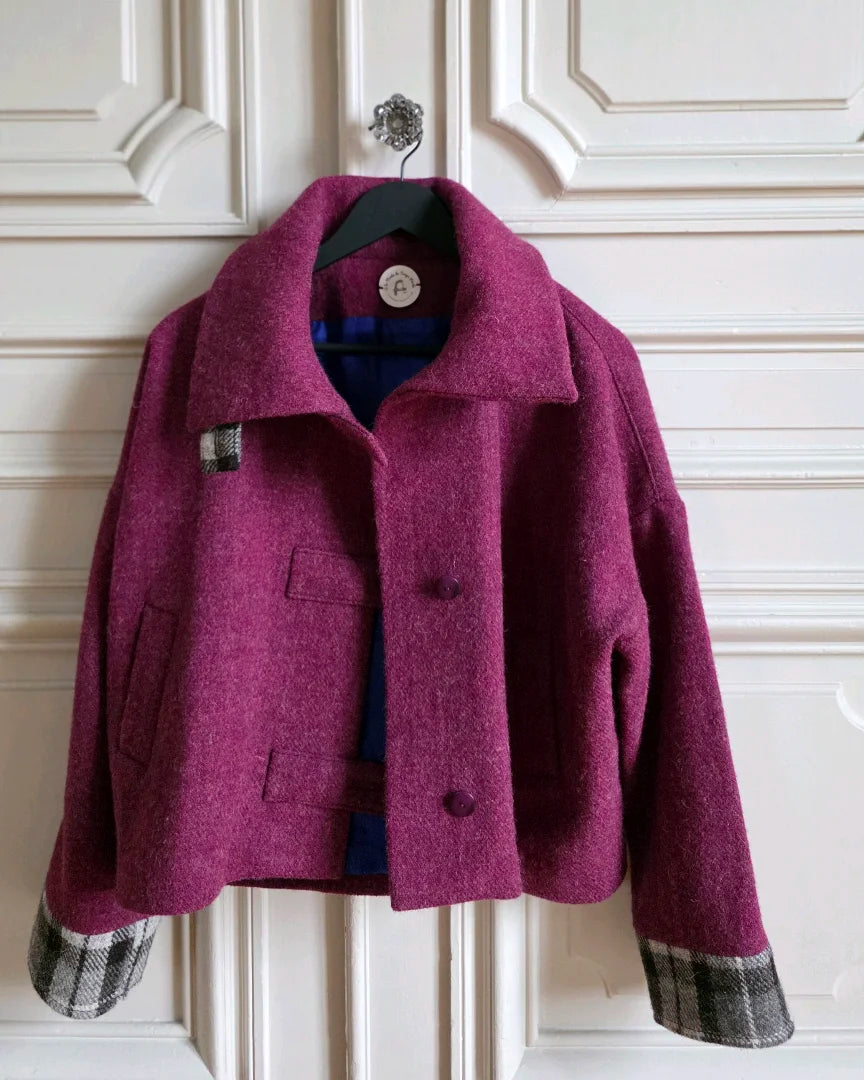 Veste Harris Tweed femme framboise ouverte sur cintre.
Étiquette A la Mode du Temps Perdu et doublure soie bleu profond visibles.
Accrochée à une porte blanche haussmannienne.