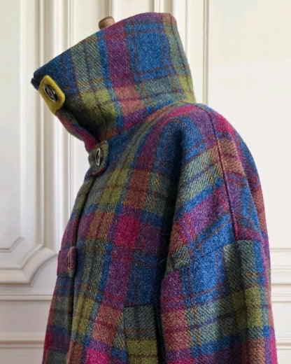 Détail de la veste Harris Tweed et soie : col montant fermé par bride unie et boutons frontaux, sur mannequin intérieur haussmannien.