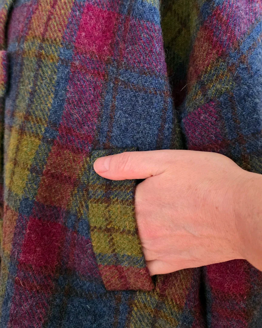 Gros plan sur la poche passepoilée doublée soie de la veste femme Harris Tweed Gilberte, main de femme glissée à l’intérieur.